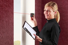 Aufmass nehmen - Decor-Union Service 098a Raumausstatterin vermisst professionell mit einem Lasermessgerät ein Fenster.