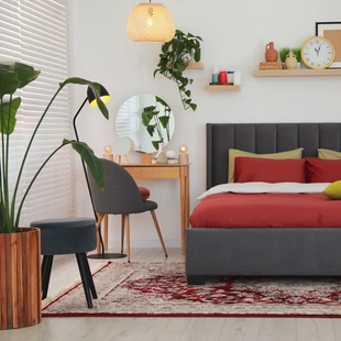 Illustration - Ihr Experte für schönes Wohnen - Stilvolles Schlafzimmer-Interieur mit bequemem Bett und Schminktisch, ein Teppich liegt unter dem Bett.
