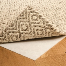 auf einem Parkettboden liegt ein hochgeklappter Teppich, darunter ist die Teppichunterlage sichtbar - auf einem Parkettboden liegt ein hochgeklappter Teppich, darunter ist die Teppichunterlage sichtbar