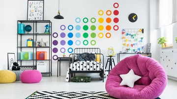 Buntes modernes Jugendzimmer mit Stickern an der Wand und einem Webteppich.