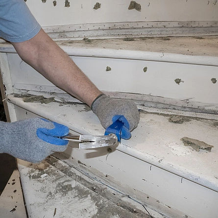 Treppenrenovierung entfernen alter Teppichstreifen von einer Holztreppe mit Hammer und Meißel - Treppenrenovierung entfernen alter Teppichstreifen von einer Holztreppe mit Hammer und Meißel
