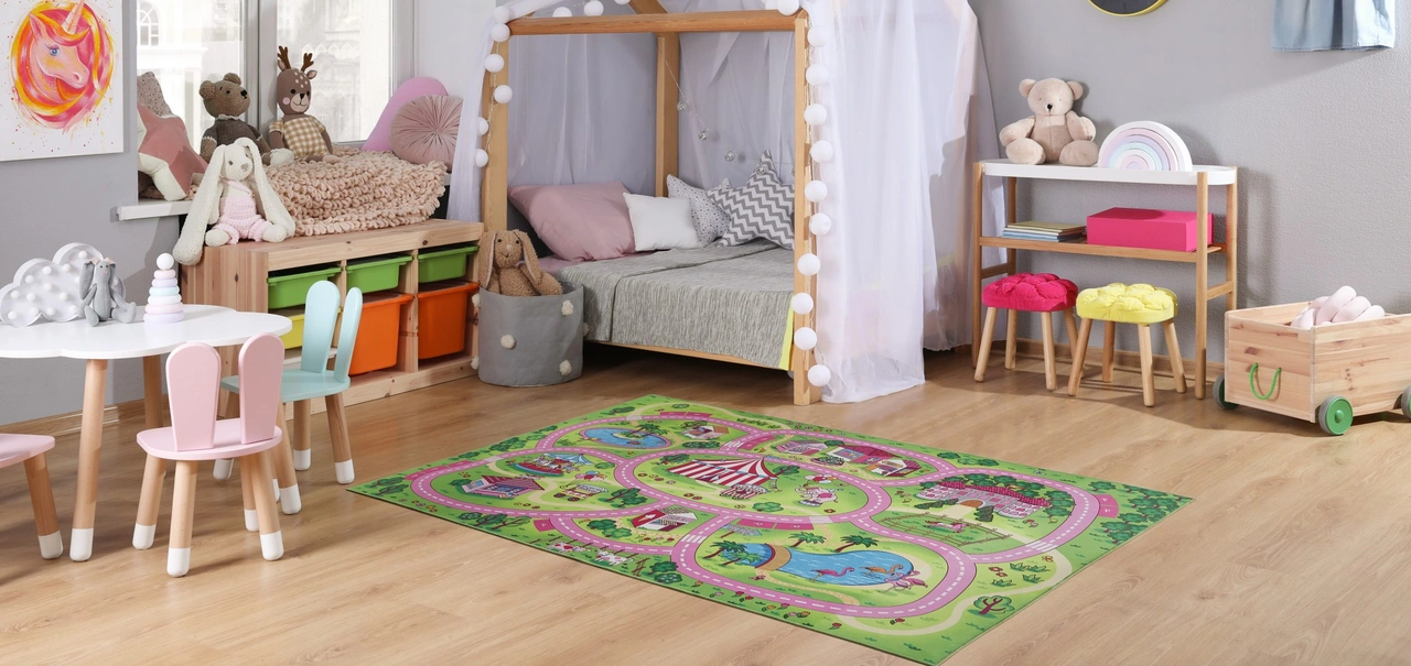 Kinder Teppiche - Kinderspielteppich der eine Landschaft mit Straßen zeigt, liegt auf dem Boden in einem Kinderzimmer.