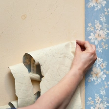 Ablösung - Renovierung, alte Tapete wird von der Wand entfernt.