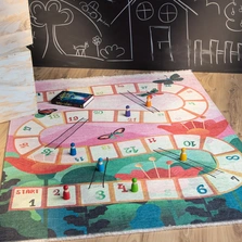 Kinderteppich - Kinderspielteppich mit einem Würfelspiel Motiv, liegt auf dem Boden.