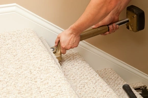 Handwerker montiert Teppichboden mit einem Stretcher auf einer Treppe - Handwerker montiert Teppichboden mit einem Stretcher auf einer Treppe