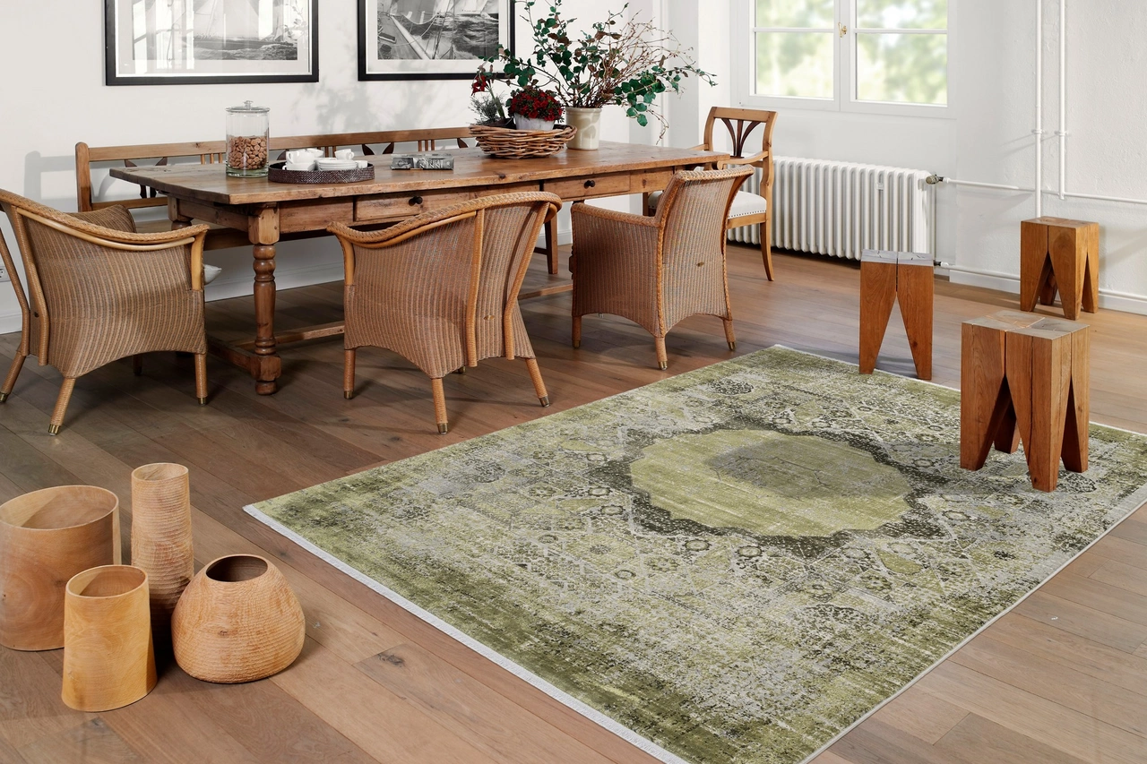 Illustration - Ihr Experte für schönes Wohnen - Ein grüner Teppich im orientalischen Muster liegt im Esszimmer auf einem Holzboden.