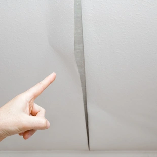 ansatzfrei - Mannes Hand Fingerzeig auf das Problem. Alte Tapete von der Decke in den Raum abziehen. - Stock-Fotografie